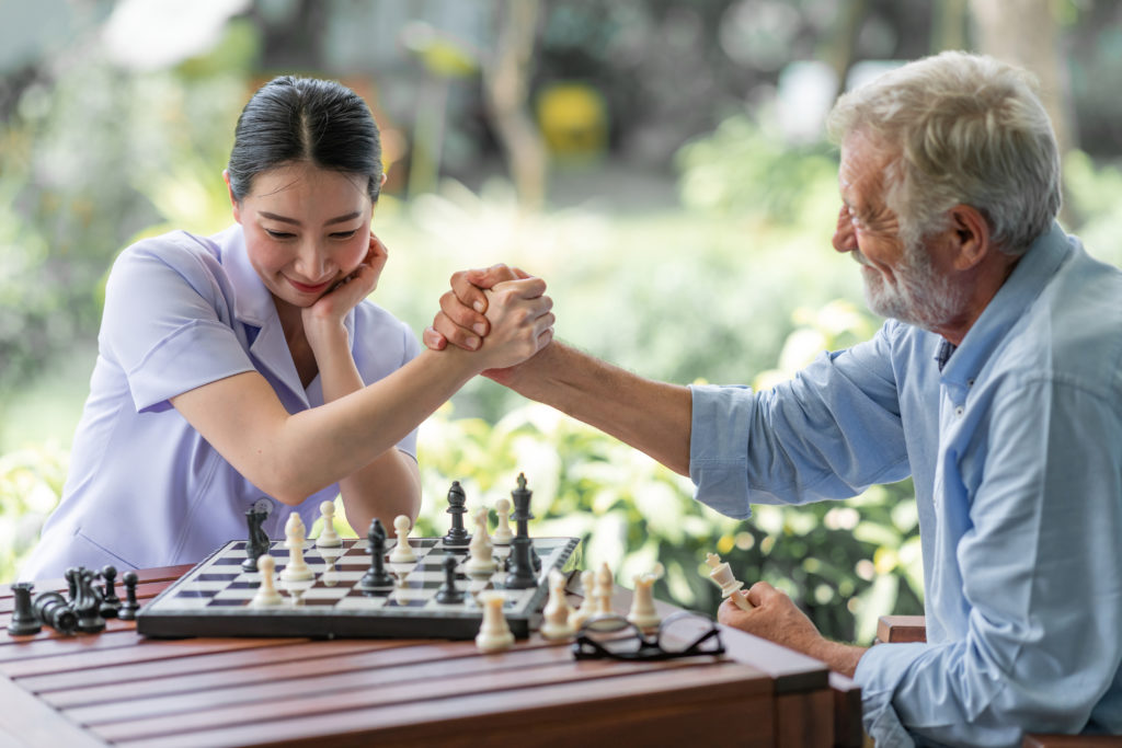 nurse playing a game with elderly man